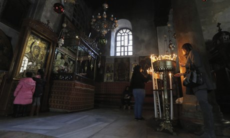 Visitors light candles in the Church of the Nativity.